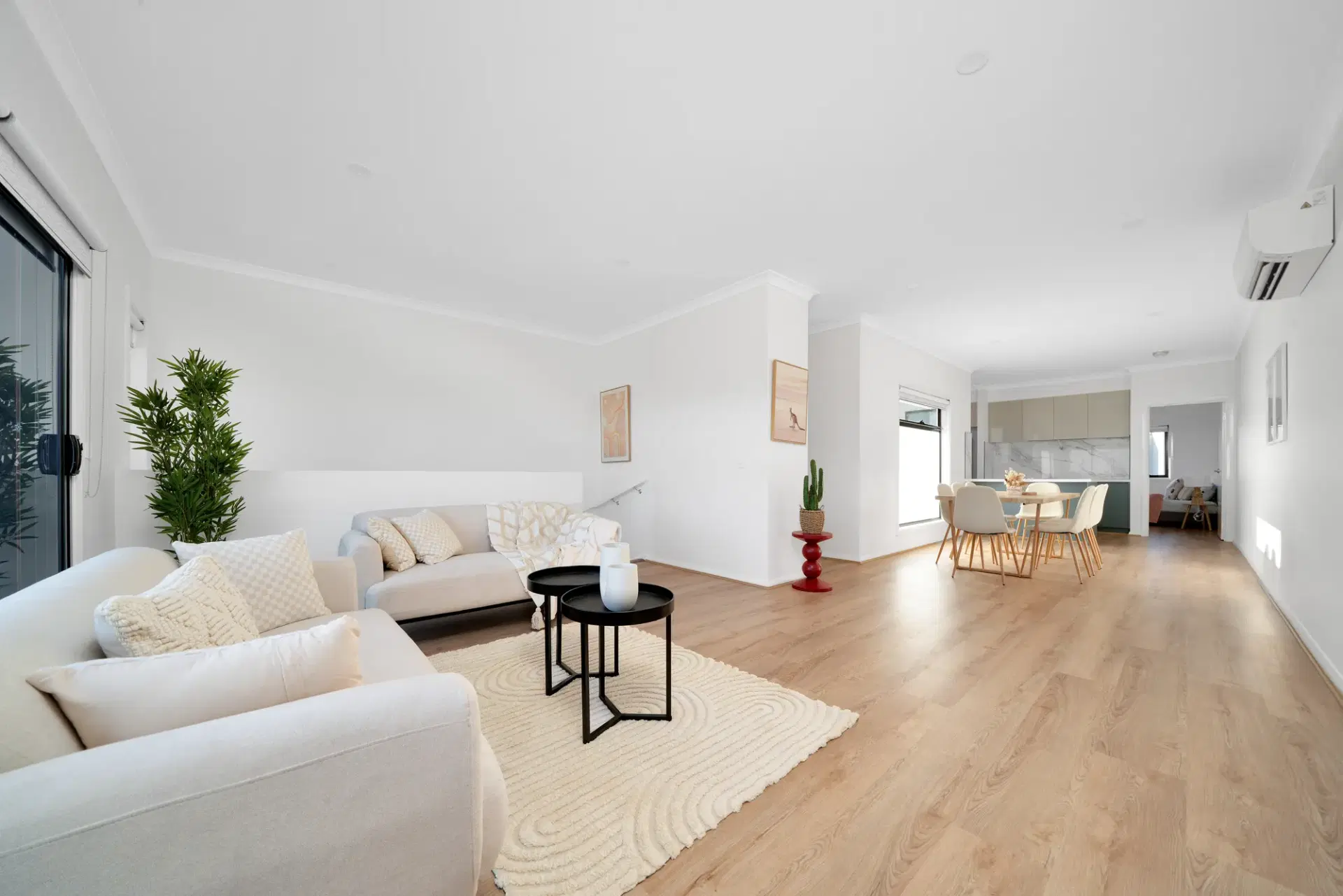 Truganina Town Homes — living room with a linen sofa, round coffee table and outlook to the dining area