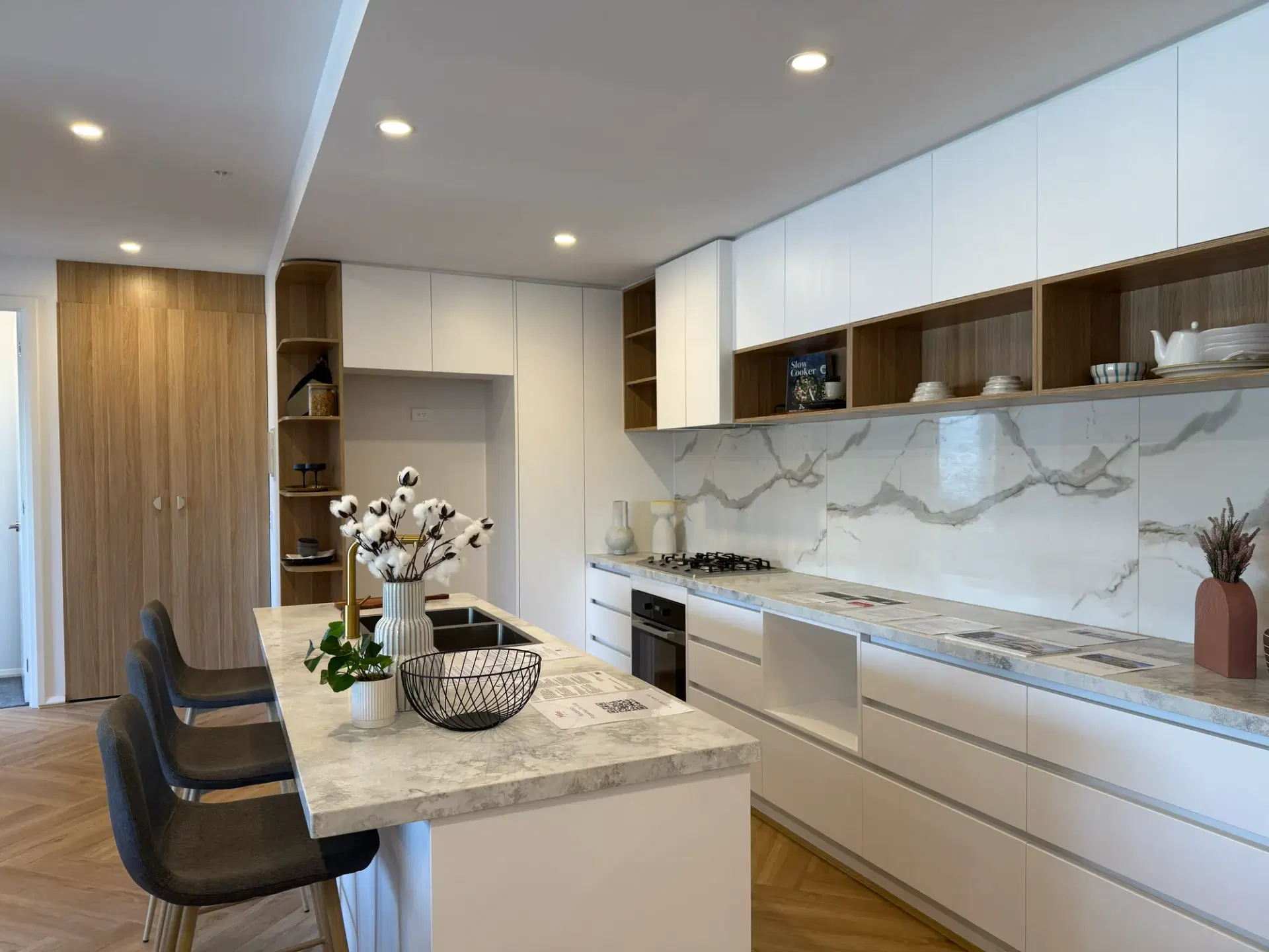 Galley kitchen in a Heidelberg apartment with marble-look splashback and full-height white joinery